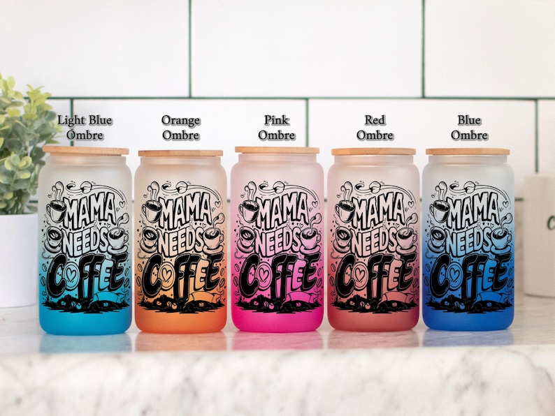 May include: Five frosted glass canisters with bamboo lids in ombre colors of light blue, orange, pink, red, and blue. Each canister has a black and white graphic that says "Mama Needs Coffee" with a heart and coffee cup design.