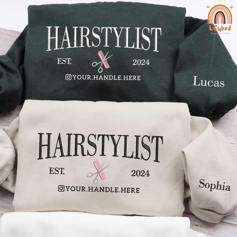 May include: Two sweatshirts with the text "HAIRSTYLIST EST. 2024" and a pair of scissors and comb graphic. The text "YOUR.HANDLE.HERE" is below the graphic. The sweatshirt on the left is green and says "Lucas" on the sleeve. The sweatshirt on the right is beige and says "Sophia" on the sleeve.