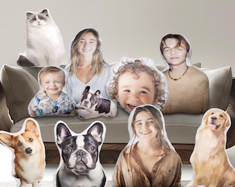 Può includere: Un set di nove federe per cuscini personalizzate con diverse immagini di persone e animali. I cuscini sono disposti su un divano con una cornice in legno. Le immagini includono un gatto, un bambino piccolo, una ragazza, una giovane donna, un cane e due cani.