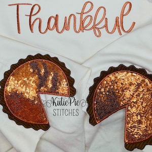 May include: Two brown and orange sequined pie patches with a slice missing. The patches are on a white background with the word "Thankful" embroidered in orange.