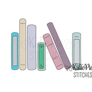 May include: An embroidery design featuring a row of seven books in various pastel colors including blue, beige, lavender, green, pink, and purple, with the text KutiePie STITCHES positioned in the lower right corner of the graphic illustration.