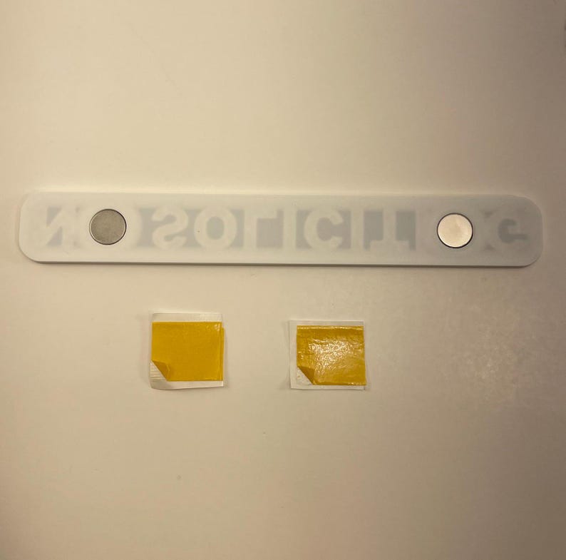 May include: A white rectangular sticker with the text "NO 201C14 XC" and two silver circles. Two yellow squares are below the sticker.