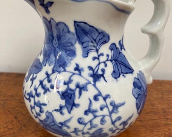 Brocca vintage in porcellana stile chinoiserie con decorazioni floreali blu e bianche.