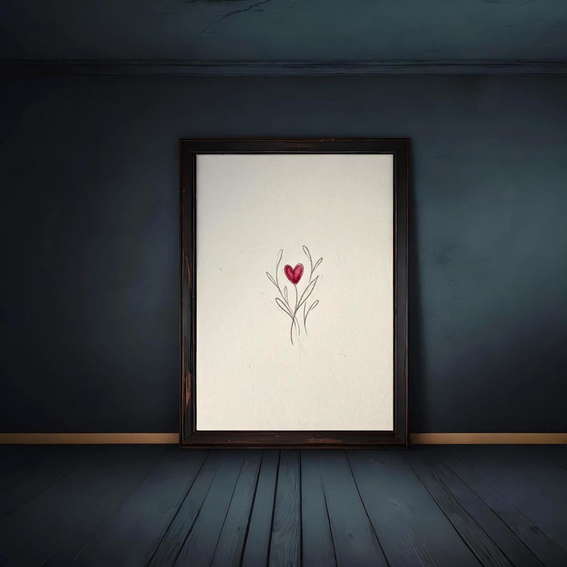 May include: A framed artwork featuring a minimalist design of a red heart atop delicate, stylized stems. The artwork is set against a cream-colored background within a dark brown wooden frame, displayed in a room with dark blue walls and floor.