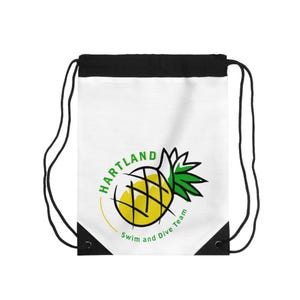 May include: White drawstring backpack with a black top and black drawstrings. The bag features a yellow and green pineapple logo with the text "HARTLAND Swim and Dive Team" in a circular design.