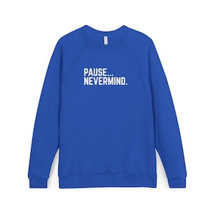 May include: Royal blue sweatshirt with the text "PAUSE... NEVERMIND" in white block letters. The long-sleeved top has a crew neck and a casual style, suitable for everyday wear.
