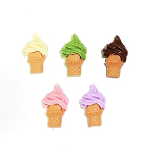 May include: Five miniature ice cream cones with different colored ice cream. The ice cream flavors are yellow, green, brown, pink, and purple.