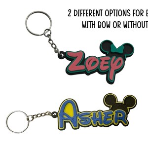 Two keychain examples shown. One girl version with a bow in teal and pink colors. The other version for a boy in yellow and dark blue colors. The girl version has a bow on the mouse head and the boy version does not.