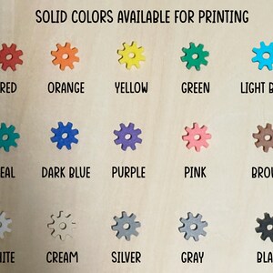 A chart showing 15 different solid colors available for printing. The colors are displayed in a grid of three rows and five columns. The colors are: red, orange, yellow, green, light blue, teal, dark blue, purple, pink, brown, white, cream, silver, gray, and black.