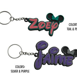 Two personalized keychains with a Mouse ear design with bow for girls. The first keychain is teal and pink with the name 'ZOEY' and the second keychain is silver and purple with the name 'JAIME'.