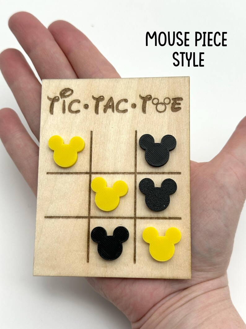 Mouse Inspired Tic-Tac-Toe game board with yellow and black Mouse head pieces. The board is made of wood and has a natural wood finish. The game board has the words 'Tic-Tac-Toe' written on it.