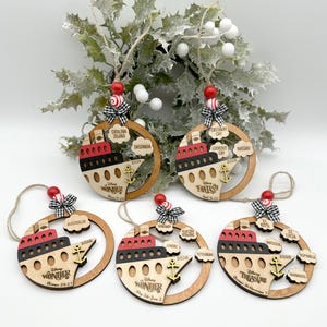A set of 5 wooden ornaments with a boat image painted in red, black and natural wood colors. The boat features a DCL ship logo, dates of the cruise and the DCL logo. It also has a anchor painted in yellow on top of the boat. The ornaments have clouds on the right side with port locations. The ornament comes with between 1-5 port location clouds. All ornaments have 2 colored wood beads, a black and white mini fabric bow and twine for hanging on top of the ornament.