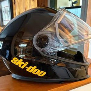 May include: Black ski helmet with a clear visor and a yellow "ski-doo" decal on the side.
