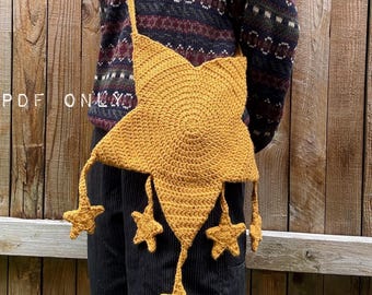 Puede incluir: Un bolso bandolera de ganchillo color amarillo mostaza con forma de gran estrella de cinco puntas, con cuatro pequeños dijes en forma de estrella que cuelgan de las puntas inferiores mediante finos cordones. El texto PDF ONLY es visible.