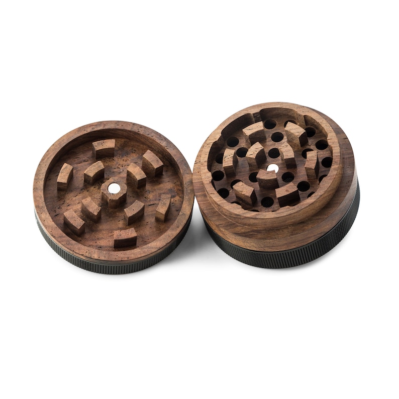 May include: Two-piece wooden grinder with a dark brown finish and a black base. The top piece has a circular pattern of teeth for grinding herbs.