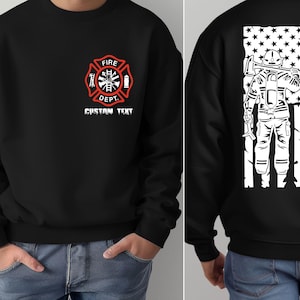 May include: Black sweatshirt with a red and white firefighter emblem on the front and a firefighter standing in front of an American flag with the word "FIREFIGHTER" on the back.