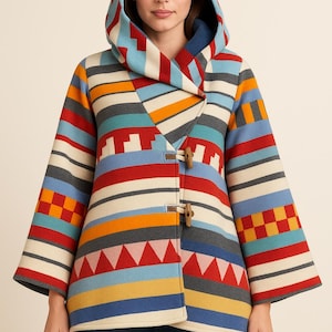 May include: A hooded coat with a colorful striped pattern in red, blue, orange, and gray. The coat features wooden toggle closures and a geometric design on the sleeves. The coat has a hood and long sleeves.