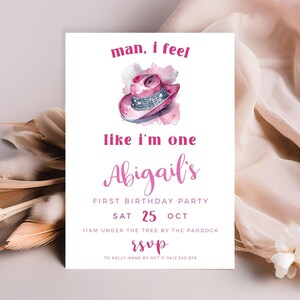 May include: Pink and white watercolor birthday party invitation with a pink cowboy hat with rhinestones. The text reads "man, I feel like I'm one Abigail's First Birthday Party Sat 25 Oct 11am under the tree by the paddock RSVP to Kelly-Anne by Oct 11 0412 345 678"