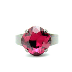 May include: A ring featuring a large, faceted, dark pink gemstone set in a silver band.