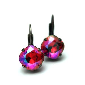 Puede incluir: Un par de pendientes con piedras de cristal rojo iridiscente engastadas en metal negro.