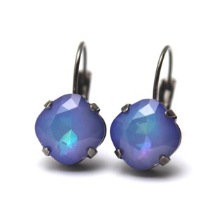 May include: A pair of silver earrings with a light blue iridescent gemstone. The earrings have a simple, elegant design.
