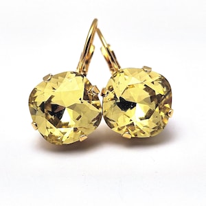 May include: A pair of gold dangle earrings with yellow crystal stones.