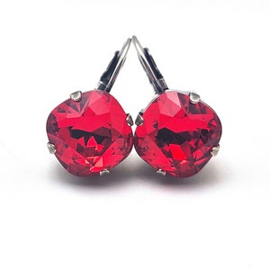 Op de afbeelding: Een paar rode kristallen oorbellen met zilveren haakjes.
