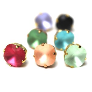 Può includere: Assortimento di strass di vetro colorati con montature dorate. Gli strass sono in tonalità di rosa, verde, blu e azzurro.