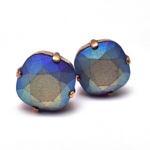 Op de afbeelding: Een paar ronde, gefacetteerde oorbellen in blauw en groen met koperen accenten.