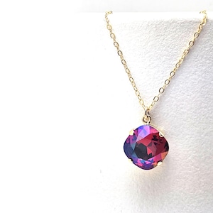 May include: A gold chain necklace with a large, square-shaped, iridescent purple and red gemstone pendant.