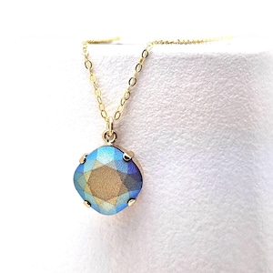 May include: A gold chain necklace with a blue and gold iridescent square pendant.