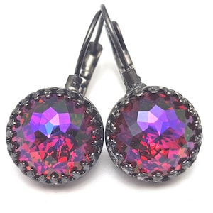 May include: A pair of dangle earrings with a black metal setting and a large, round, iridescent red and purple gemstone.