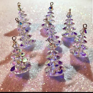 Può includere: Sette decorazioni per albero di Natale a forma di albero di cristallo iridescente con filo d'argento e un anello d'argento per appendere.