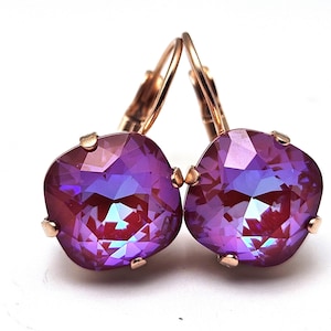 May include: A pair of rose gold earrings with square-shaped purple iridescent crystals.