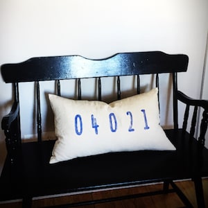 May include: A black wooden bench with a white pillow featuring the blue text "04021".