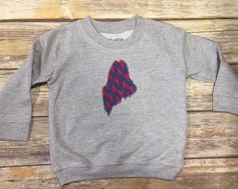 May include: A gray sweatshirt with a blue and red lobster print of the state of Maine.