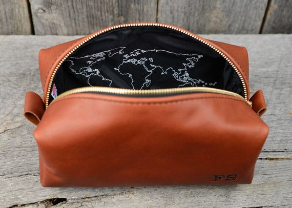 Holiday Gift Guide for Travelers with world map embroidered leather toiletry bag