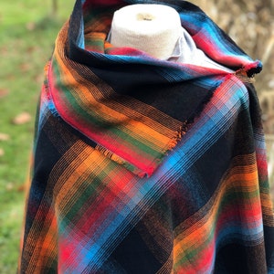 Fabric poncho on a bust for display, Black Cotton Rainbow Plaid with Cowl Collar and Fringe