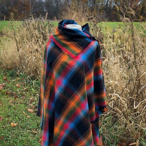 Fabric poncho on a bust for display, Black Cotton Rainbow Plaid with Cowl Collar and Fringe