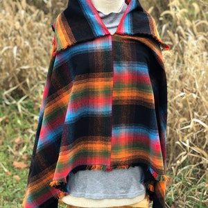 Fabric poncho on a bust for display, Black Cotton Rainbow Plaid with Cowl Collar and Fringe