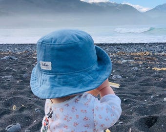 Cappello da sole a secchiello in velluto a coste azzurro, con cinturini sotto il mento