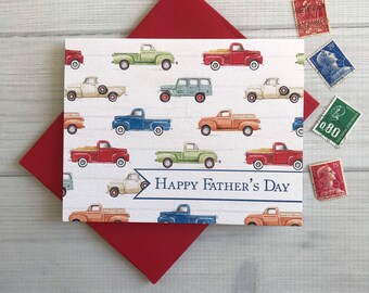 May include: A Father's Day card with a red envelope. The card displays a pattern of vintage pickup trucks in different colours, with the text "Happy Father's Day" on a banner. Several vintage postage stamps are scattered around the card.