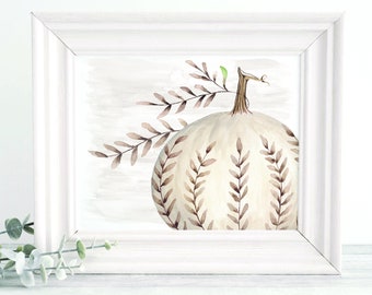 May include: A framed watercolour painting of a white pumpkin with brown leaf accents. The pumpkin features vertical leaf patterns and a brown stem. The background is a light grey wash, all within a white frame.