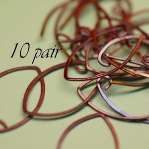 May include: A close-up of 10 pairs of copper wire earring hooks. The hooks are a reddish-brown color and are arranged in a pile.