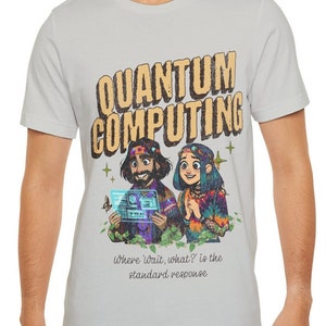 May include: A light gray t-shirt with a vintage-style graphic of two people with the text "Quantum Computing" and the phrase "Where 'wait, what?' is the standard response".