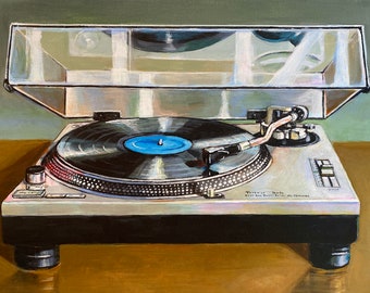 May include: A silver and black turntable with a clear dust cover. The turntable has a black vinyl record on the platter with a blue label. The turntable has a silver tone arm and a silver control panel with black buttons.