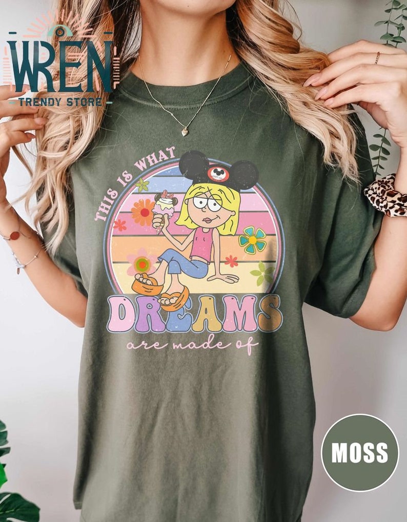 Puede incluir: Una camiseta verde con un gr&aacute;fico retro de una chica de dibujos animados con un sombrero de Mickey Mouse y sosteniendo un cono de helado. El gr&aacute;fico est&aacute; rodeado de flores y un arco&iacute;ris. El texto "This is what dreams are made of" est&aacute; escrito en una fuente colorida.
