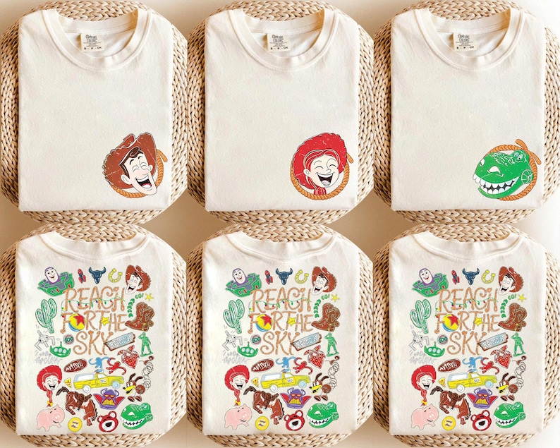 K&ouml;nnte beinhalten: Cremefarbene T-Shirts mit Toy Story Charaktergrafiken. Die obere Reihe zeigt die Gesichter von Woody, Jessie und Rex. Die untere Reihe zeigt eine Collage aus Charakteren und den Text "REACH FOR THE SKY" in einem farbenfrohen Design.