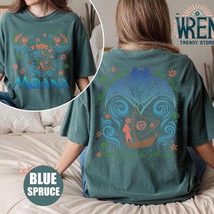 May include: A teal blue t-shirt with a graphic print of Moana from the Disney movie Moana. The front of the shirt features a colorful design with Moana's name and the back of the shirt features a design of Moana sailing on a boat with the text "The ocean chose you to be with you".
