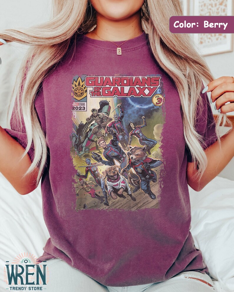 Pu&ograve; includere: Una t-shirt color granata con un design di fumetto vintage con i Guardiani della Galassia. La copertina del fumetto recita "Guardians of the Galaxy Vol. 3" e "Marvel Comics 2023".